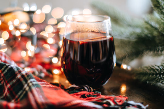 Egy pohár forralt bor a karácsonyi asztalon.