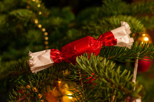 Klasszikus piros csomagolású szaloncukor a karácsonyfán.