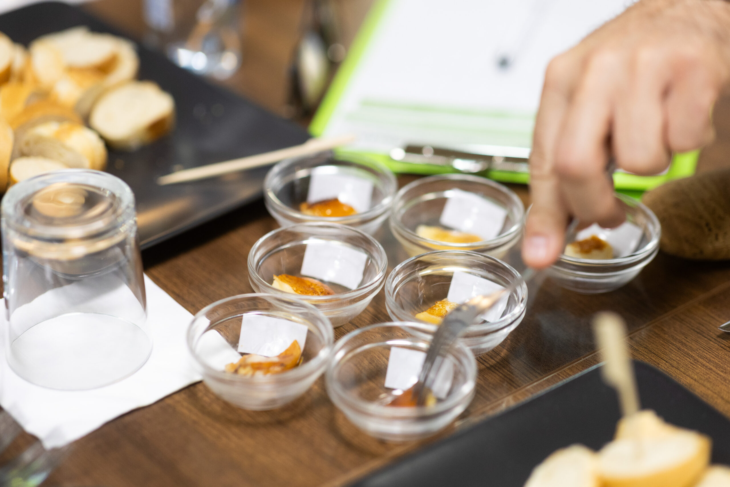 A képen egy asztalon hat darab kis üveg tálkában grillsajt-falatok vannak.