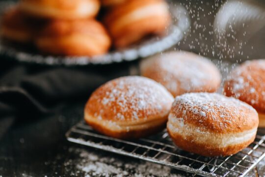 Porcukorral szórt szalagos fánkok az asztalon.