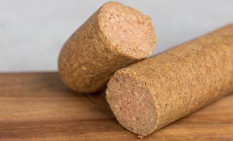 Kettévágott kutyaszalámi egy deszkán.